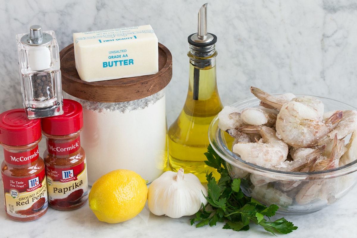 Gamberetti Hawaiani All'aglio Image of ingredients used to make Hawaiian garlic shrimp. Includes raw shrimp, olive oil, parsley, garlic, lemon, flour, butter, paprika, cayenne pepper, salt and pepper.