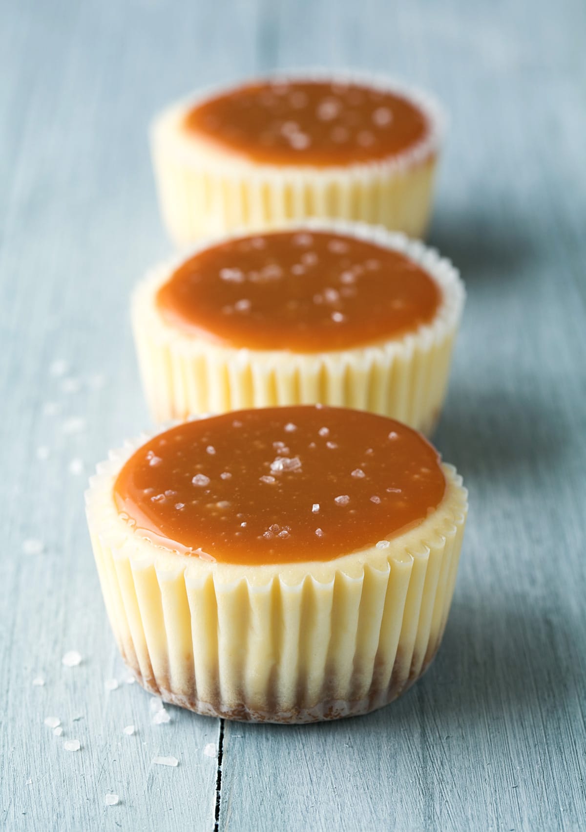 Tre mini cheesecake di fila condite con salsa al caramello salata.