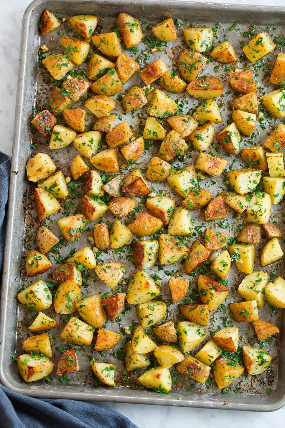 Patate Al Forno Al Limone. Lemon seasoned yukon roasted potatoes on a baking sheet shown overhead.