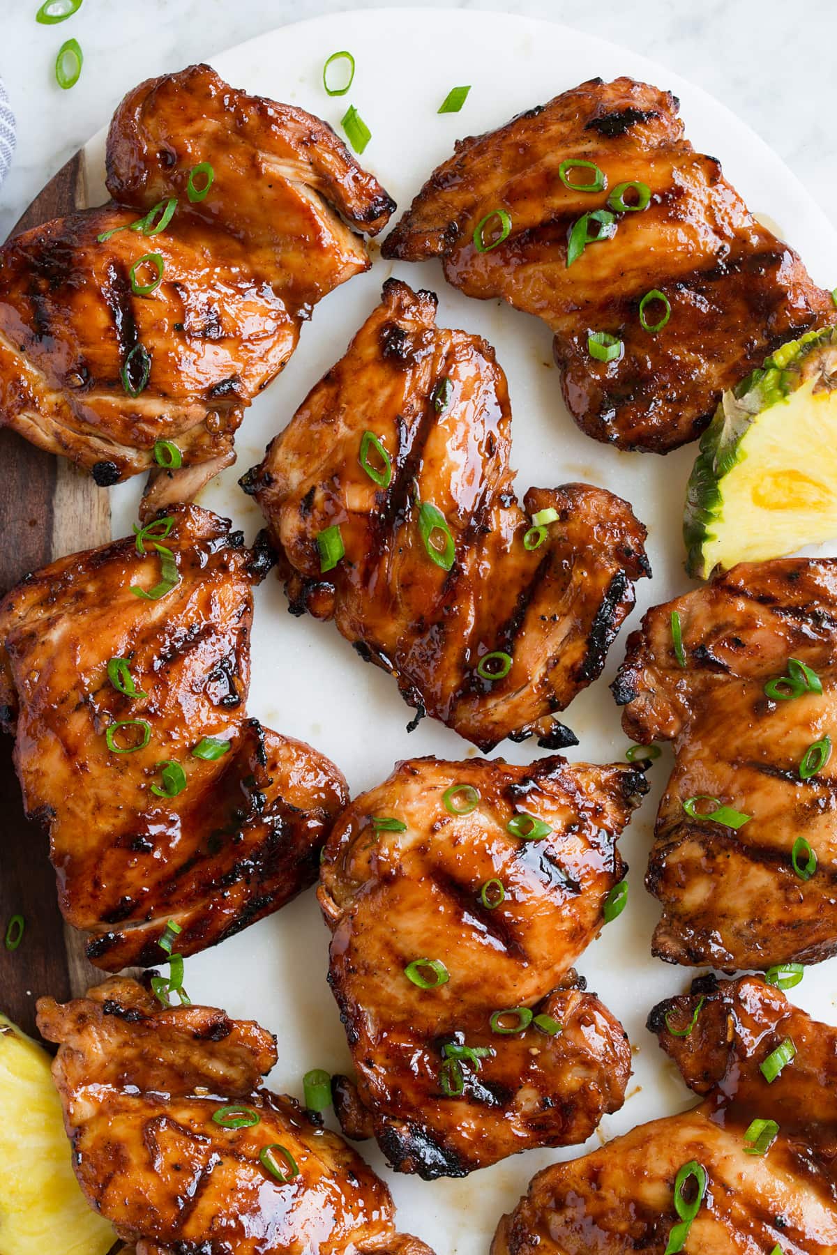 Pollo Huli Huli Close up image of huli huli chicken thighs on a platter. Shown overhead.