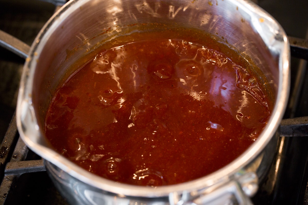 Salsa barbecue fatta in casa BBQ sauce simmering on stovetop.
