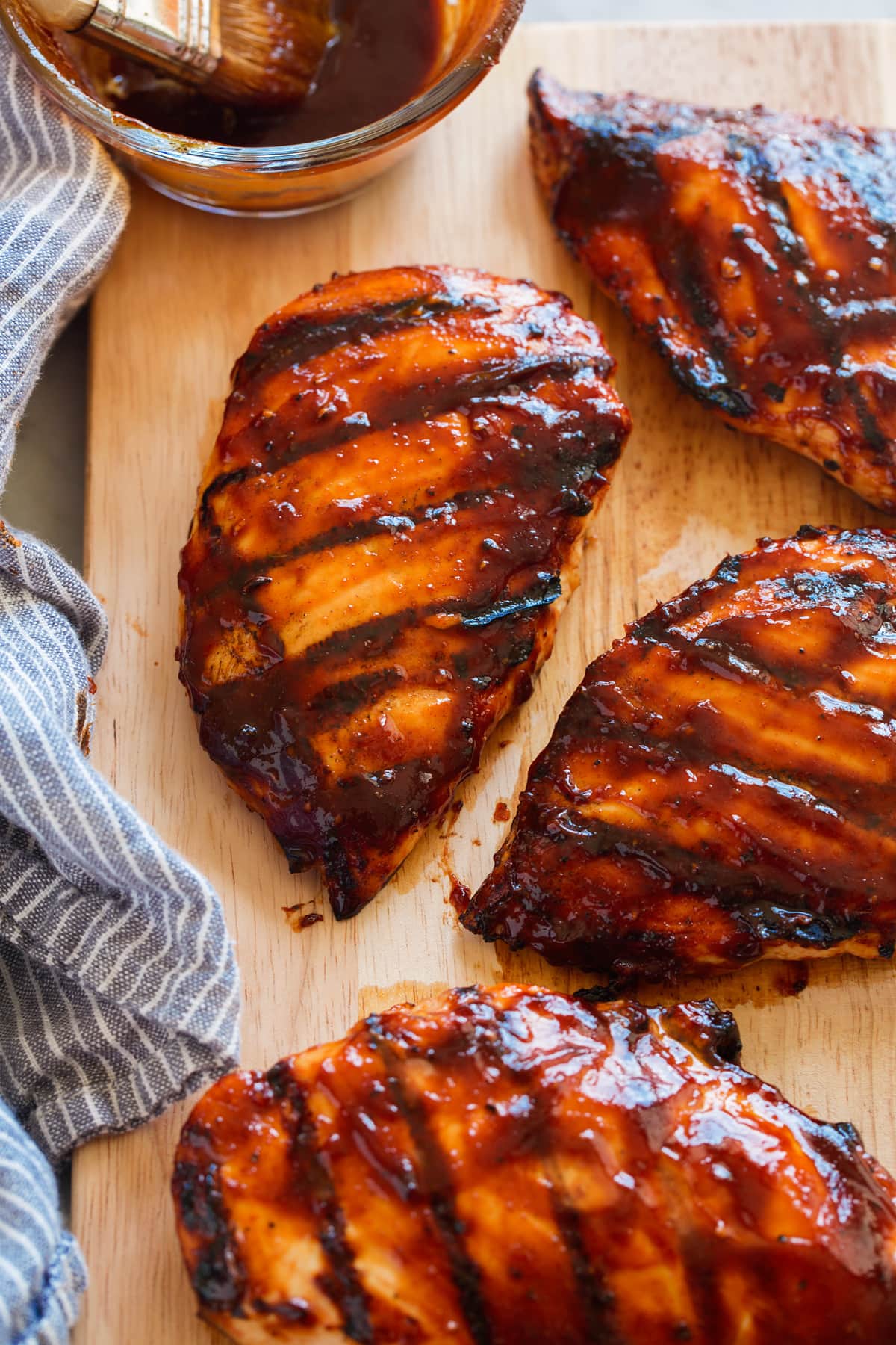 Salsa barbecue fatta in casa Grilled chicken breasts covered in bbq sauce on a wooden cutting board.