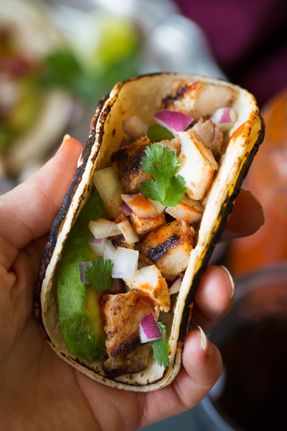 Mano che tiene un mini taco di strada, mostrato da vicino.