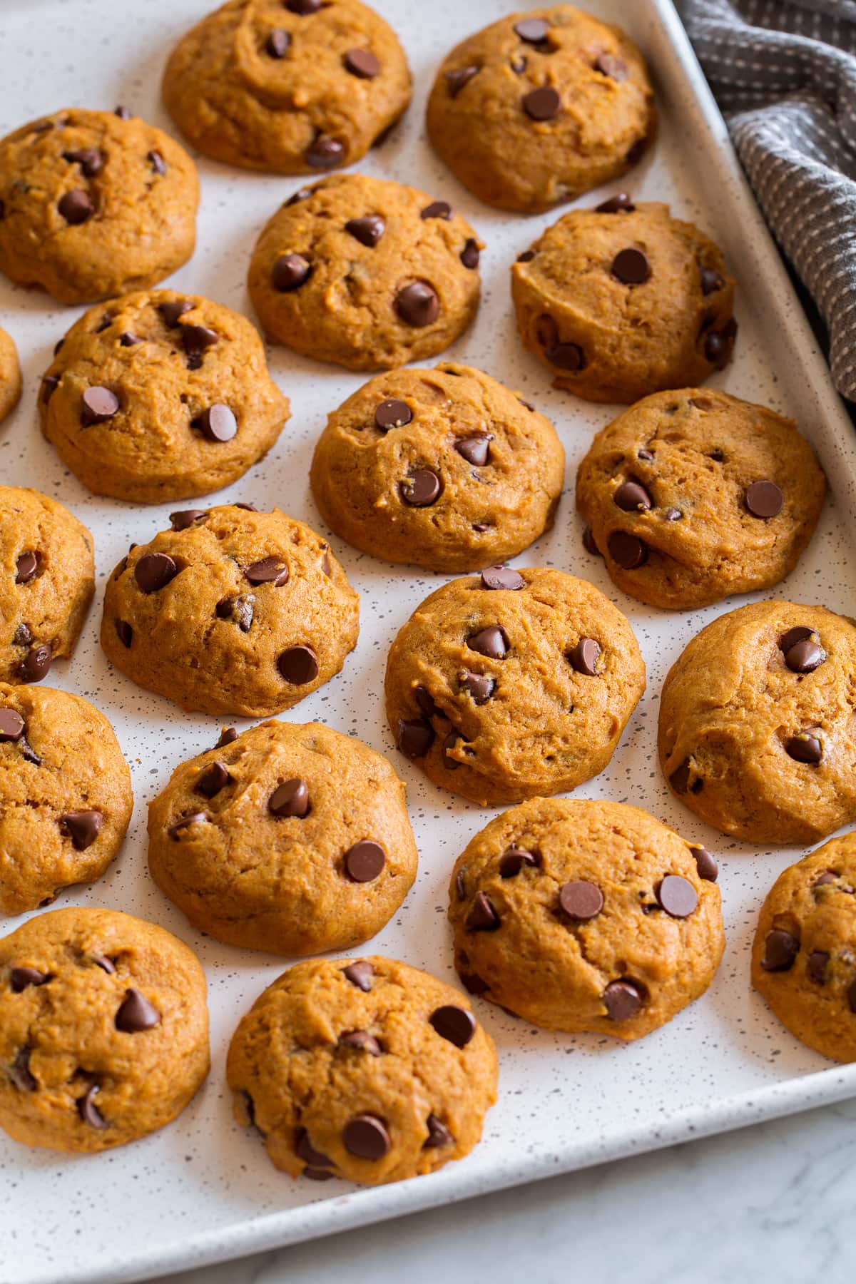 Rows of pumpkin cookies on a baking sheet.