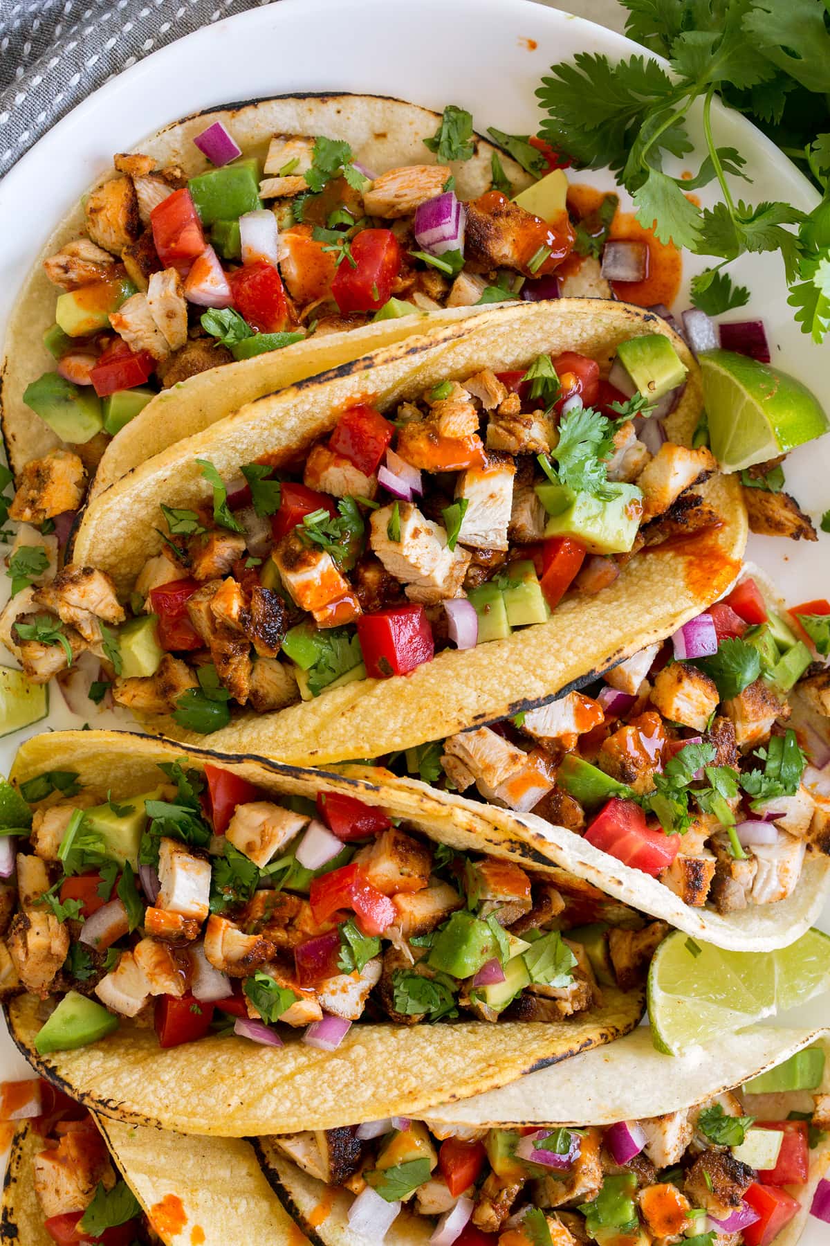 Taco di pollo Close up image of chicken tacos in corn tortillas with various toppings such as onions, cilantro and tomatoes.