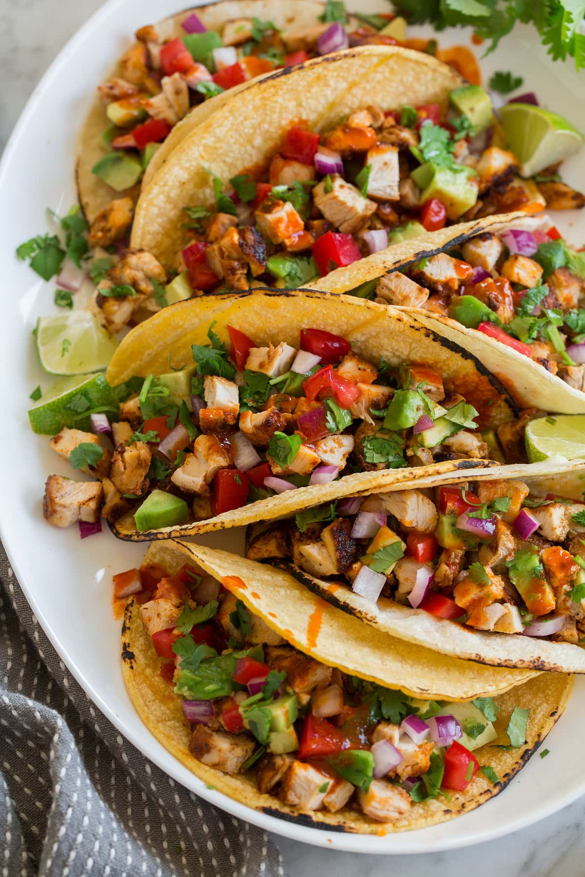 Taco di pollo Chicken tacos on a platter shown from a side angle.
